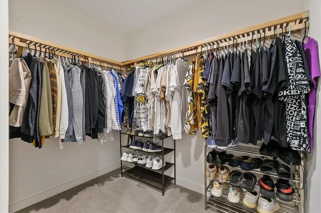 a view of walk in closet with clothes and shoes