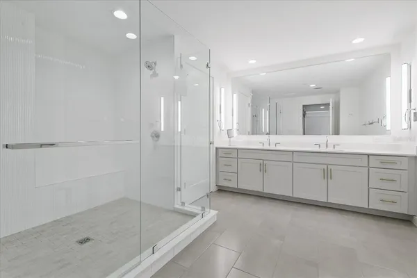 a spacious bathroom with a double vanity sink mirror and shower