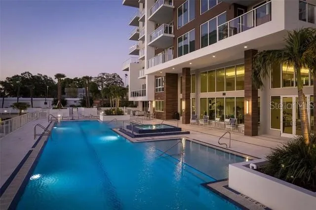 a view of a building and a swimming pool with an outdoor seating