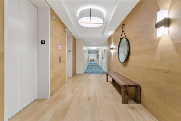 a view of a hallway with wooden floor and staircase