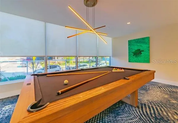 a room with pool table and windows