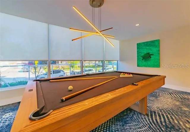a room with pool table and windows