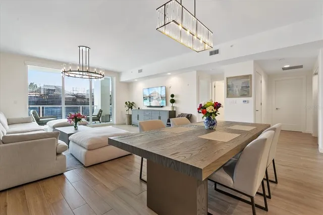 a view of a dining room with furniture wooden floor and chandelier