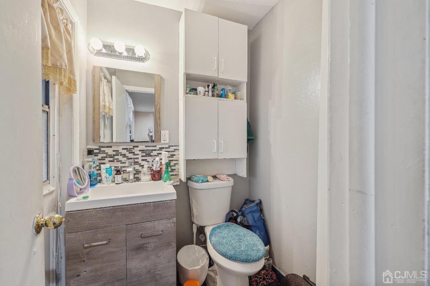 1096 Rudyard Drive Perth Amboy, NJ 08861 - Photo 9 of 10 a bathroom with a granite countertop toilet sink and mirror