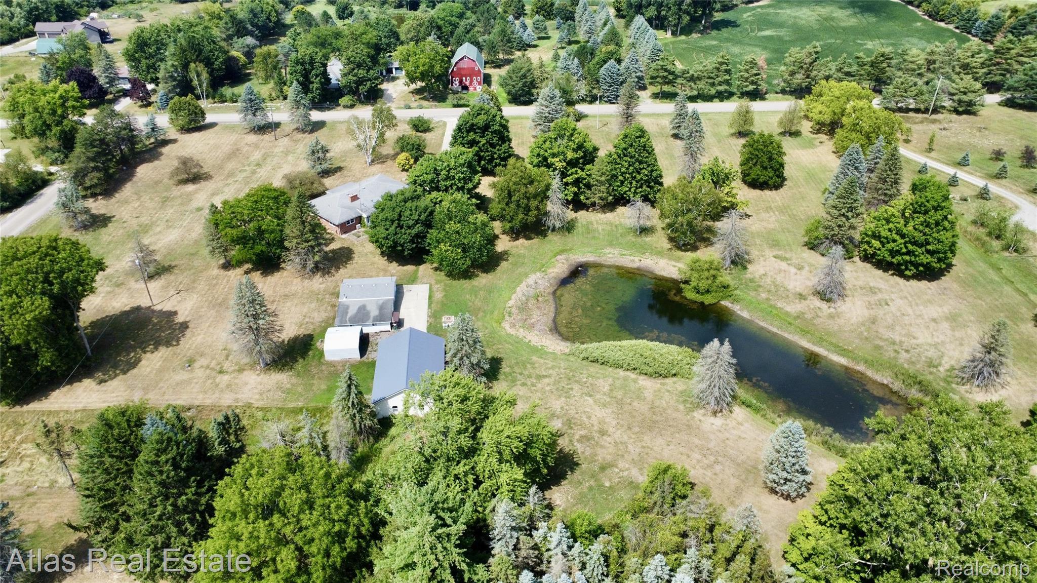 12026 Coolidge Road Goodrich, MI 48438 - Photo 17 of 56 Expansive property featuring a pond, mature trees, and multiple residential structures