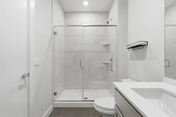 a bathroom with a sink a toilet and shower