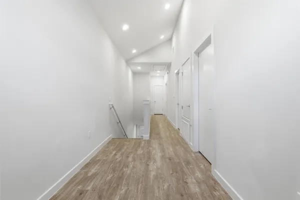 a view of a room with wooden floor and white walls