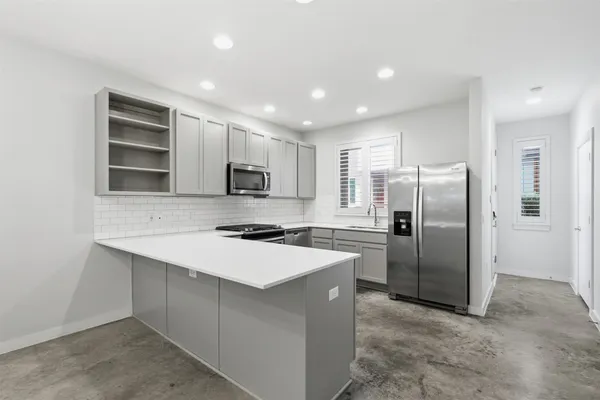 a kitchen with stainless steel appliances a refrigerator sink and microwave