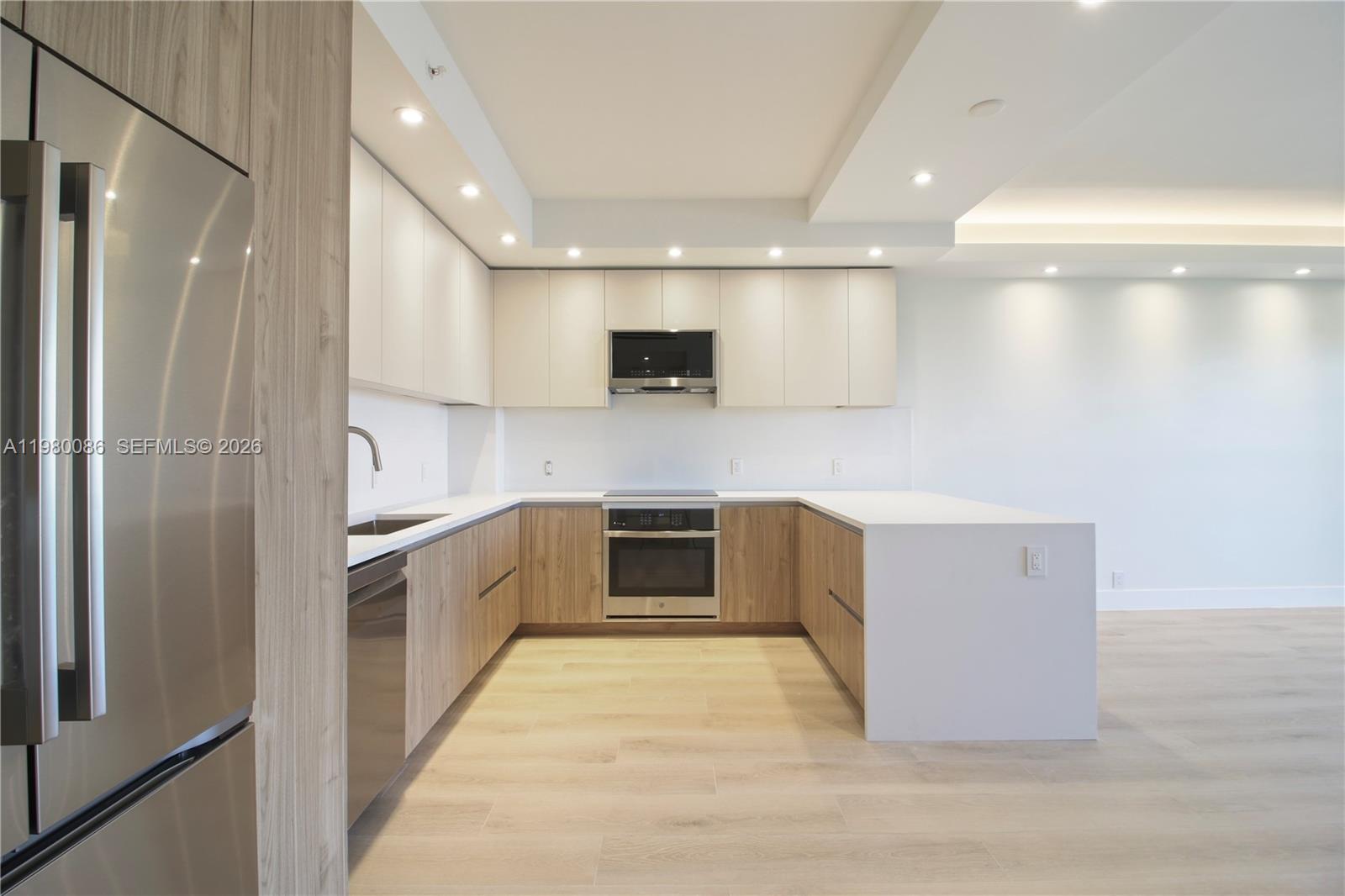 151 Crandon Boulevard, Unit 540 Key Biscayne, FL 33149 - Photo 14 of 41 a large kitchen with a large counter top stainless steel appliances and cabinets