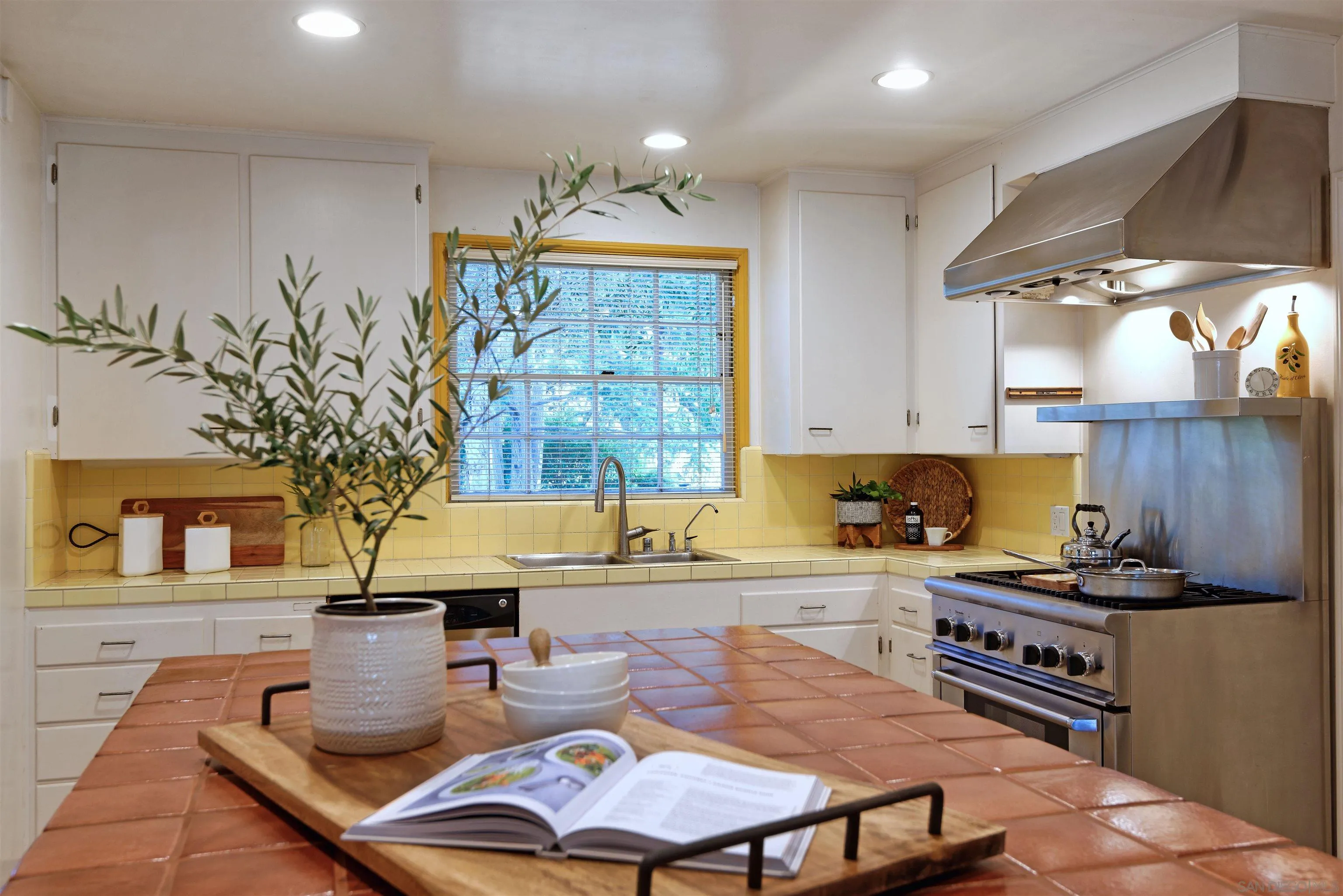1780 La Jolla Rancho Road La Jolla, CA 92037 - Photo 8 of 24 a kitchen with a stove a sink a table and chairs
