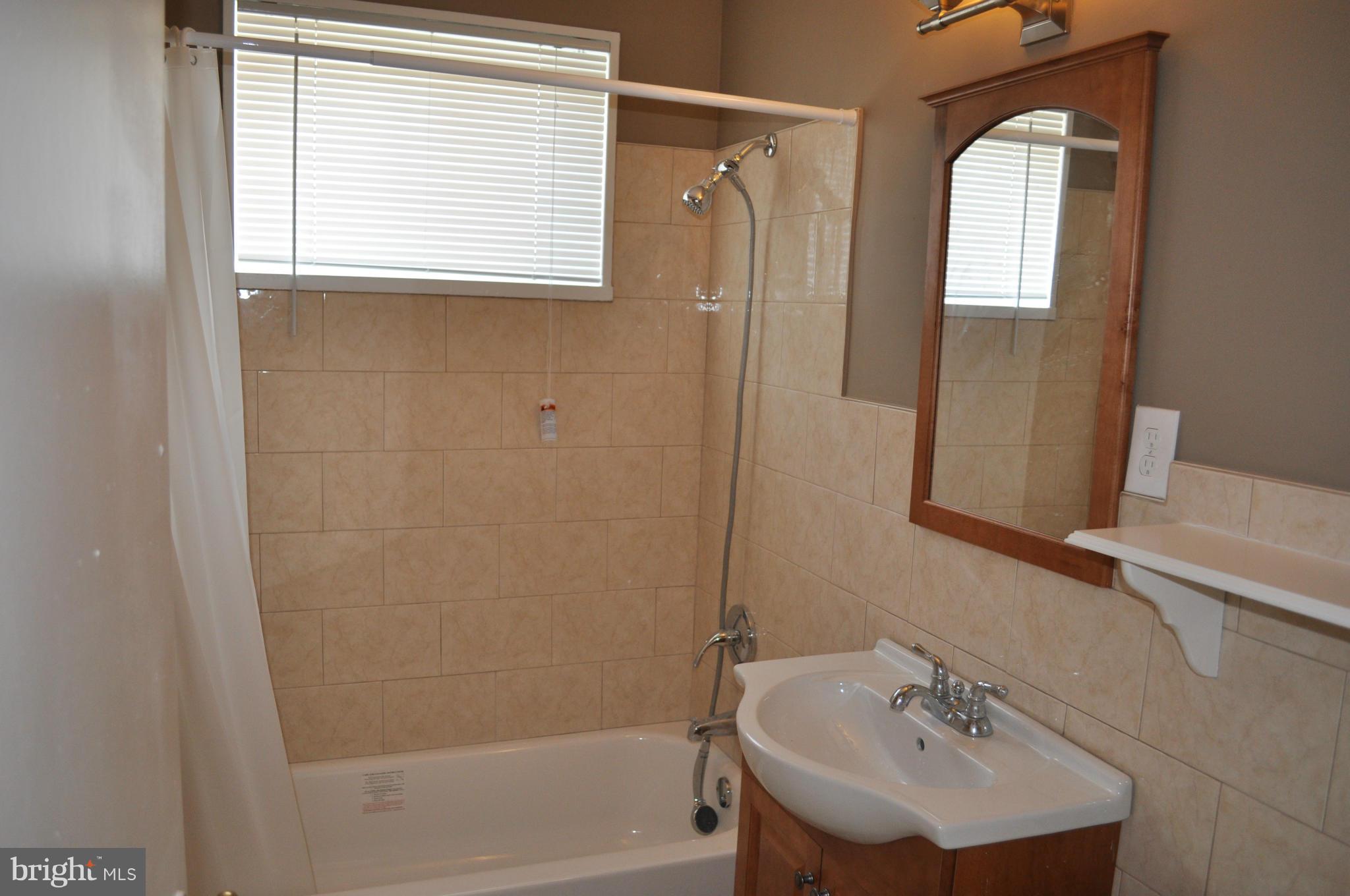 1108 Navahoe Drive Silver Spring, MD 20903 - Photo 10 of 14 a bathroom with a sink a mirror and a bathtub