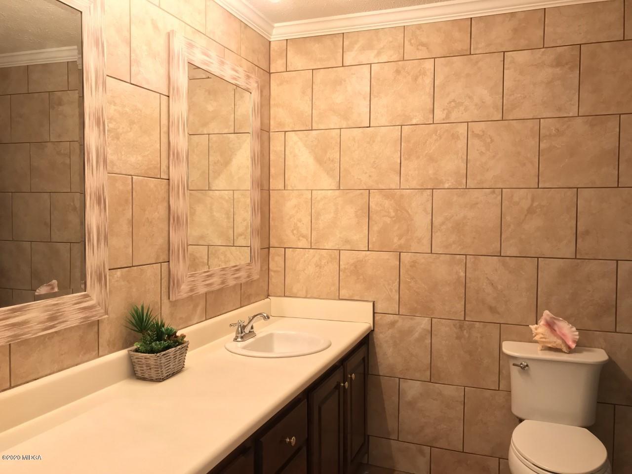 6669 Goodall Mill Road Macon, GA 31216 - Photo 17 of 28 a bathroom with a sink a toilet and mirror