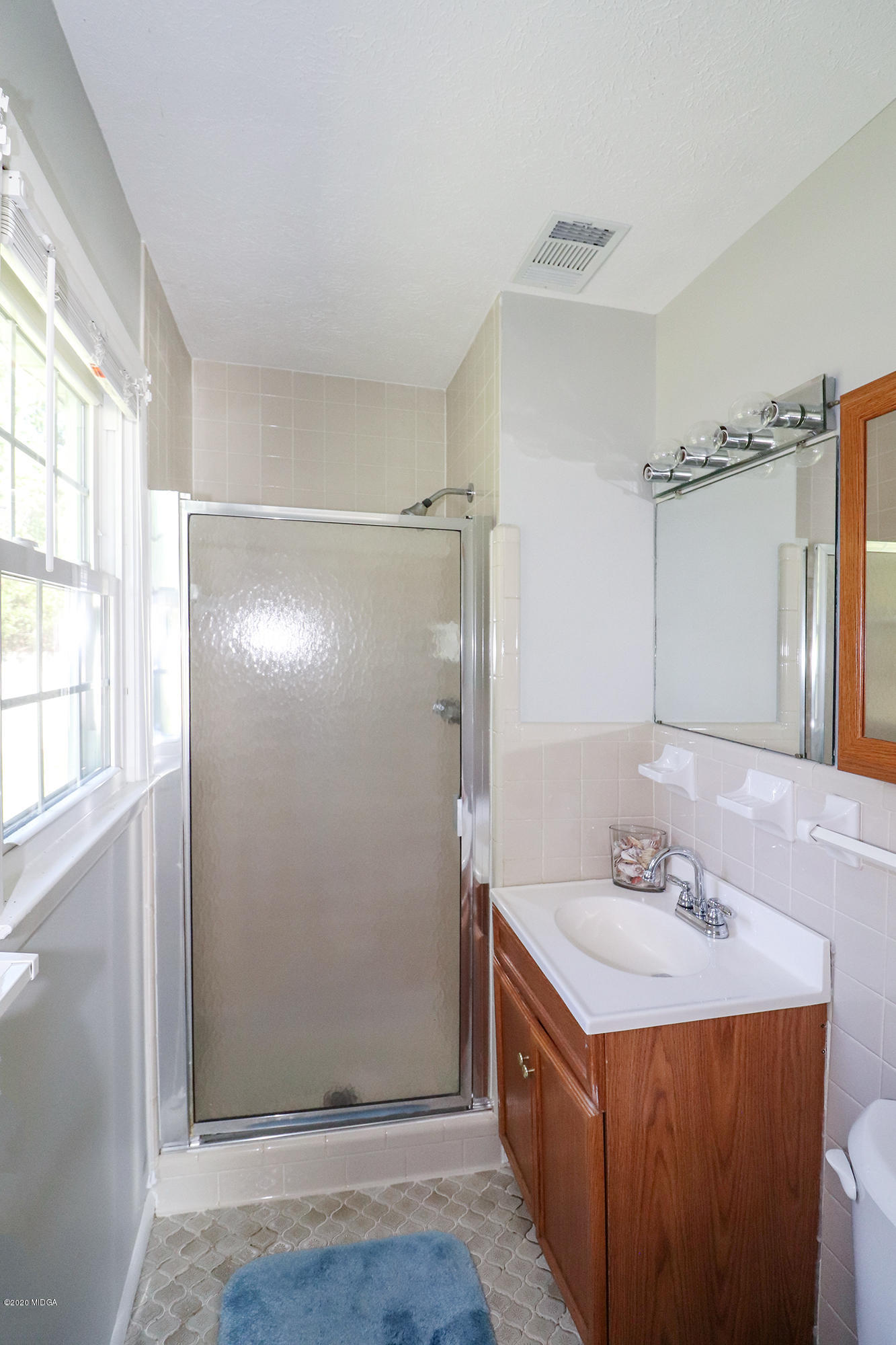 6669 Goodall Mill Road Macon, GA 31216 - Photo 19 of 28 a bathroom with a shower sink and mirror