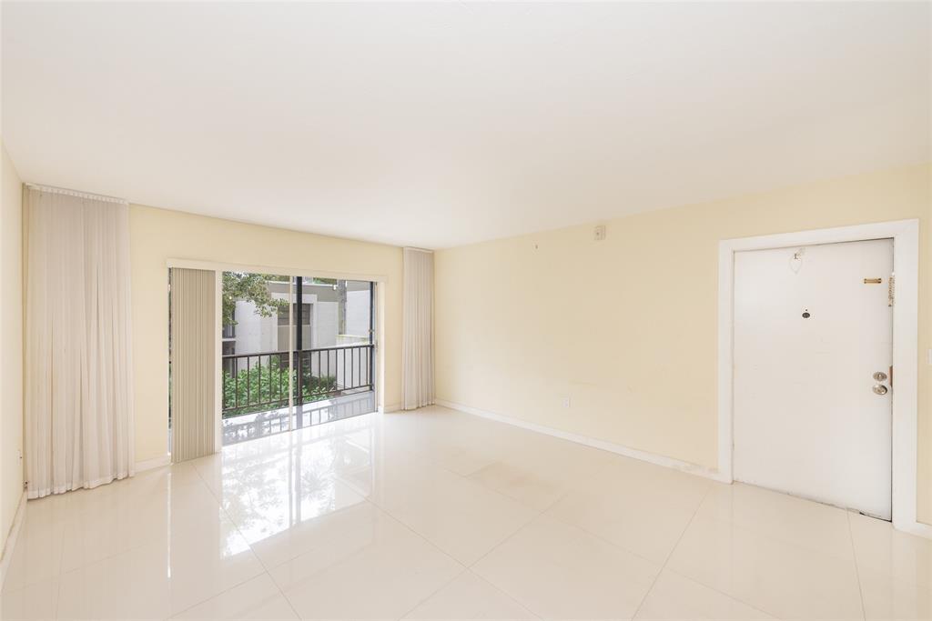 7925 Southwest 104th Street, Unit 203E Miami, FL 33156 - Photo 8 of 23 a view of an empty room with wooden floor and a window