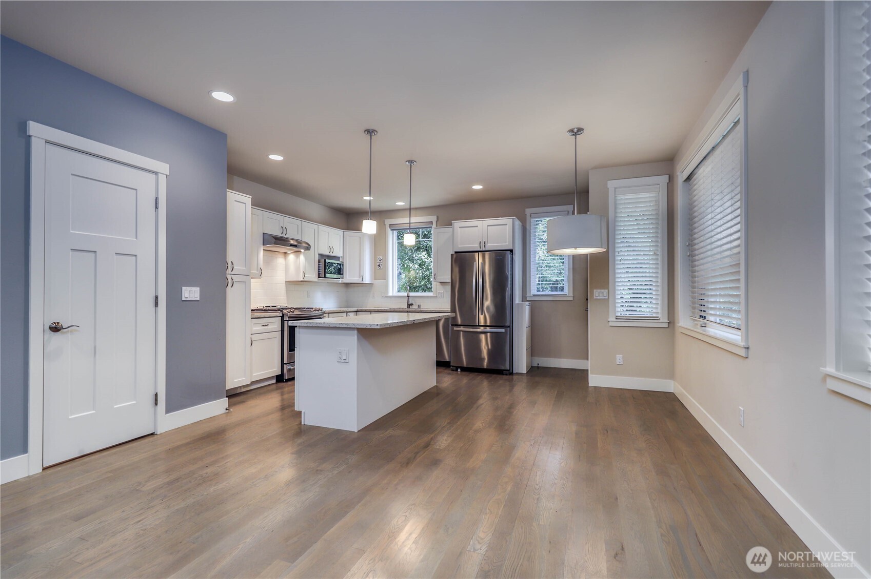 690 Wintersweet Road Northeast Bainbridge Island, WA 98110 - Photo 6 of 23 a large kitchen with stainless steel appliances kitchen island a large counter top and wooden floors