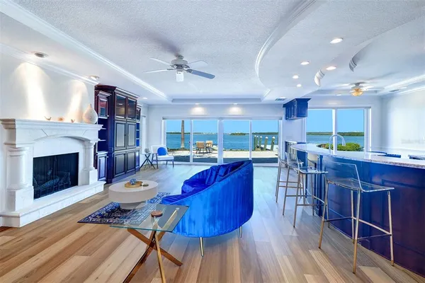 a living room with furniture a fireplace and a kitchen view