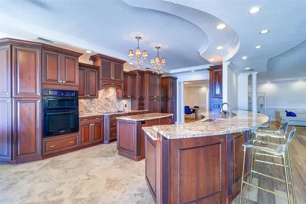 a kitchen with kitchen island granite countertop a sink stove and cabinets