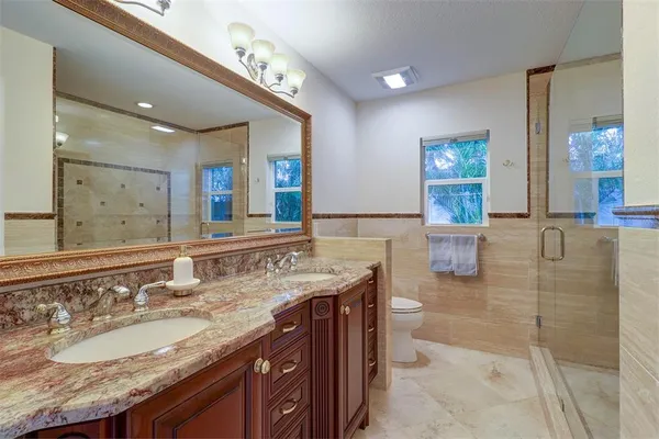 a bathroom with a granite countertop sink a large mirror and shower