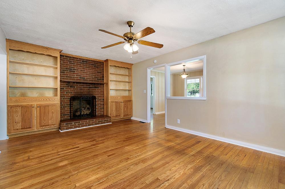 210 Pitt Lane Springfield, TN 37172 - Photo 6 of 27 an empty room with wooden floor fireplace and a window