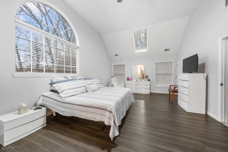 a spacious bedroom with a bed and a flat screen tv