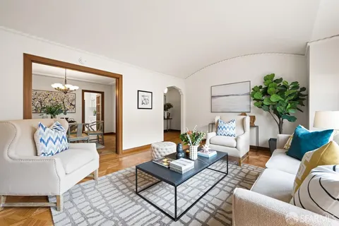 a living room with furniture potted plant and a large window