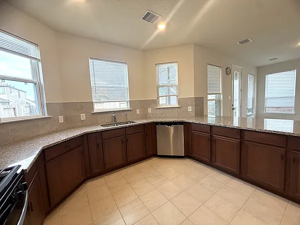 a large kitchen with granite countertop a sink and dishwasher with a large window