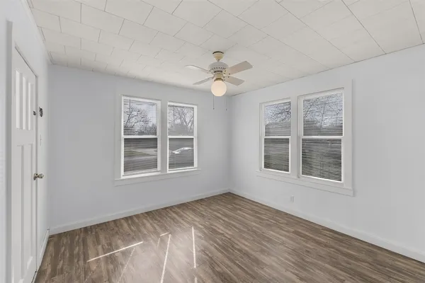 an empty room with a window and a ceiling fan