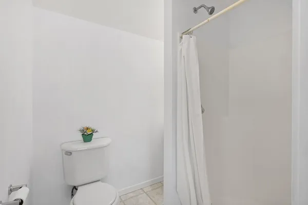 a white toilet sitting next to a shower