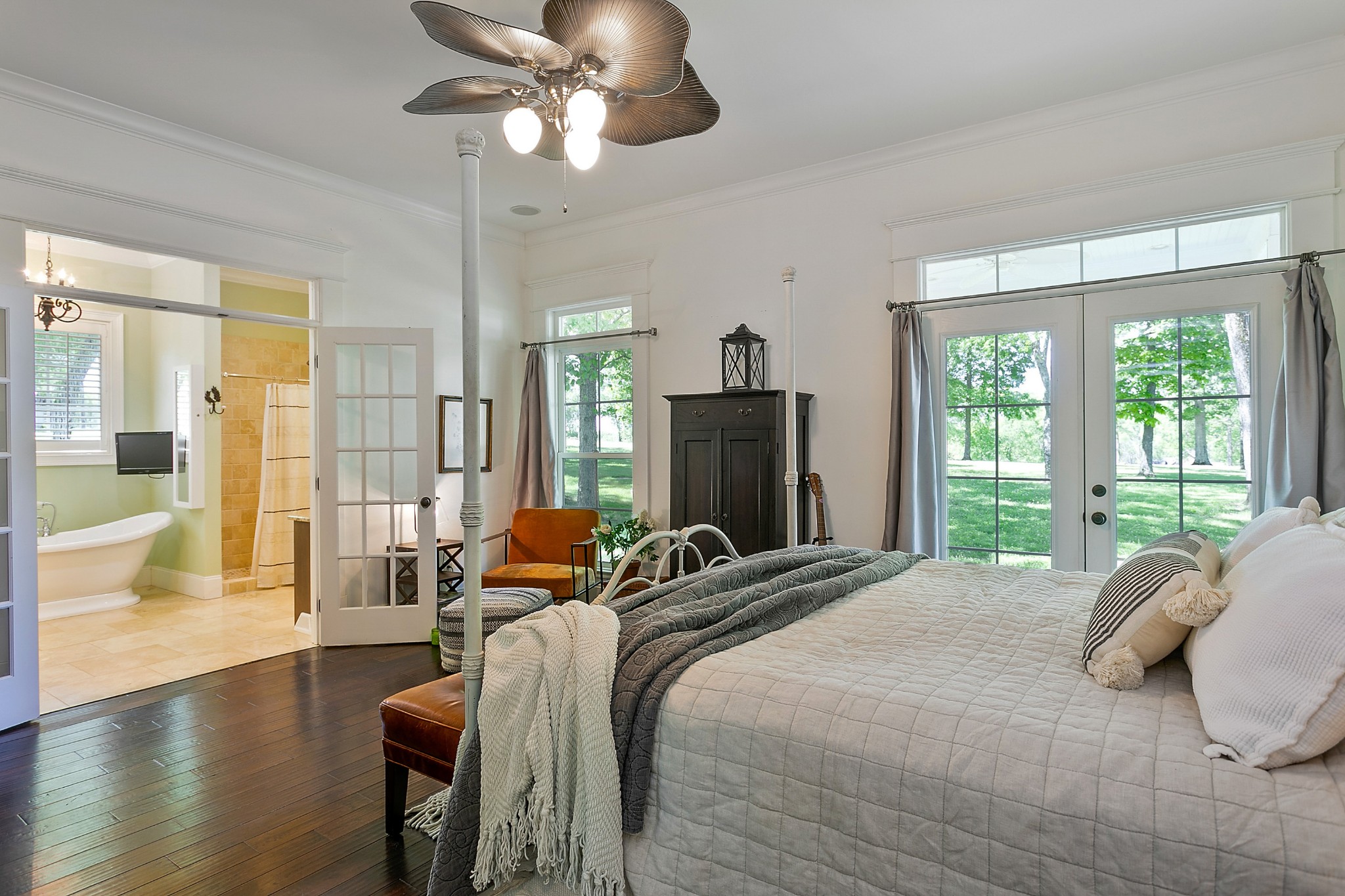 4280 Central Valley Road Murfreesboro, TN 37129 - Photo 25 of 50 On the main level, behind solid French doors, the hardwood floors flow into this owner's suite. Large glass double doors lead out onto the covered wrap-around porch and into the large ensuite bathroom.