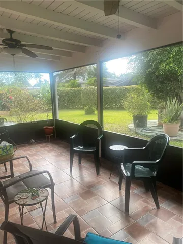 a living room with patio furniture and a floor to ceiling window