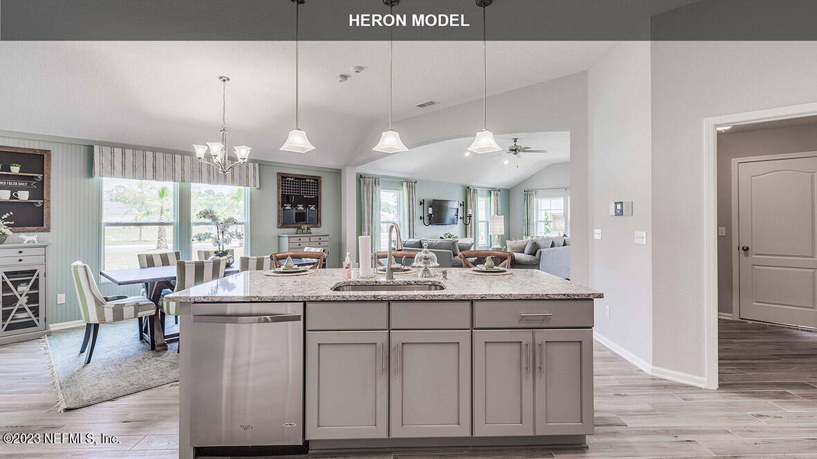 65776 Edgewater Drive Yulee, FL 32097 - Photo 11 of 45 a kitchen with kitchen island granite countertop a sink cabinets and wooden floor