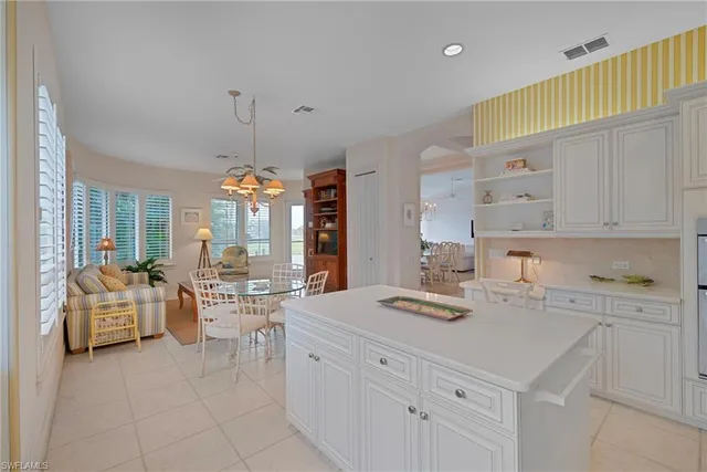 a kitchen with a white cabinets and chandelier
