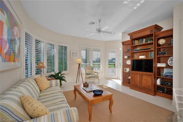 a living room with furniture a flat screen tv and a window