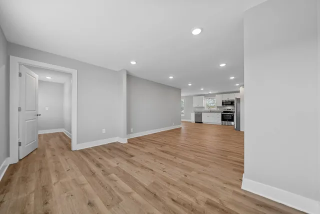 a view of empty room with wooden floor