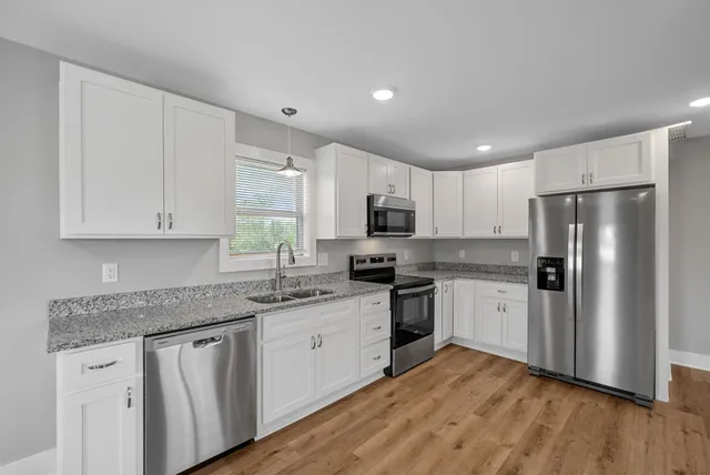 a kitchen with stainless steel appliances granite countertop a refrigerator sink and microwave