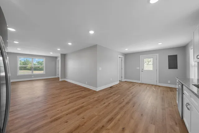 a view of empty room with wooden floor and window
