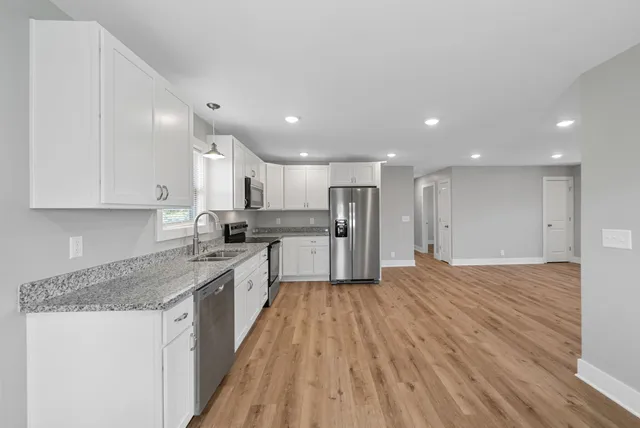 a large kitchen with stainless steel appliances granite countertop a large counter top and a stove top oven