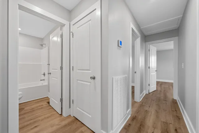 a view of a hallway with wooden floor