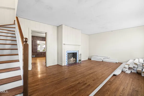 a view of a livingroom with wooden floor and a fireplace