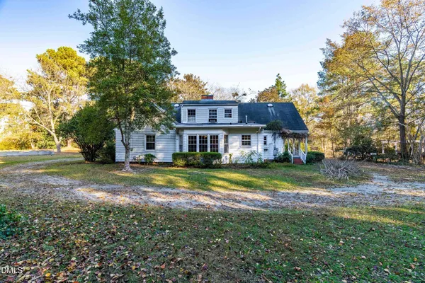 a front view of house with yard and trees in the background