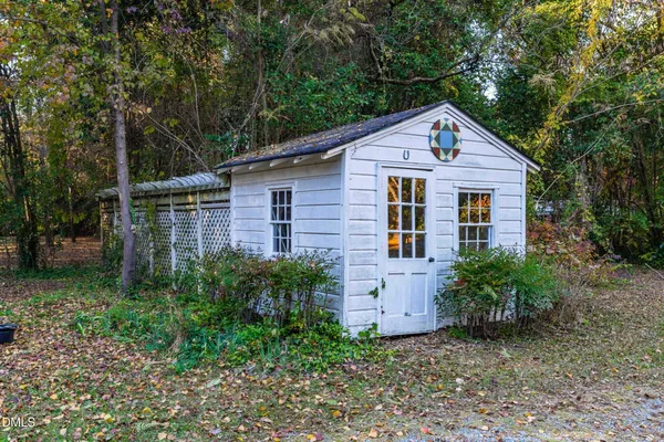 a view of a house with a small yard plants and large tree