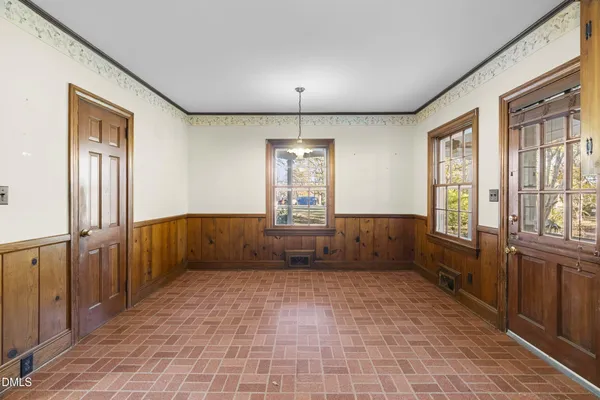 a view of an empty room with a fireplace and windows