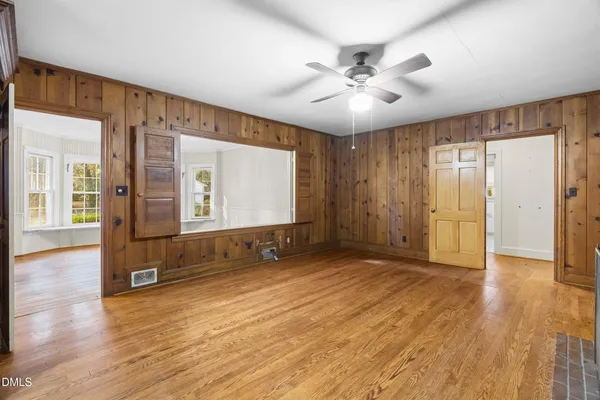 a view of an empty room with window and wooden floor
