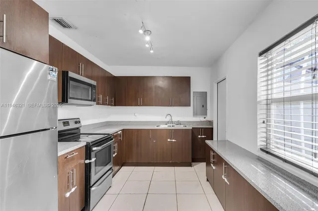 a kitchen with stainless steel appliances granite countertop a sink and a stove