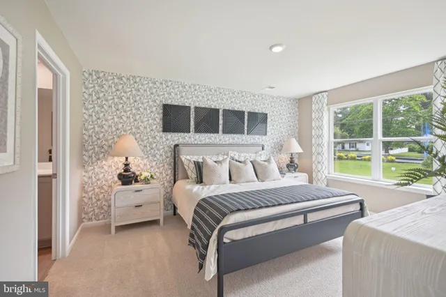 a bedroom with a bed and a lamp on dresser