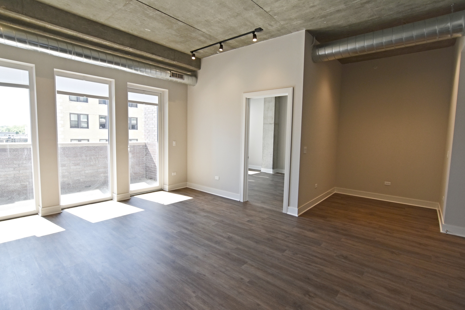 3833 North Broadway, Unit 409 Chicago, IL 60613 - Photo 6 of 14 a view of an empty room with wooden floor and a window