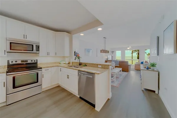 a kitchen with stainless steel appliances granite countertop a refrigerator and a stove top oven