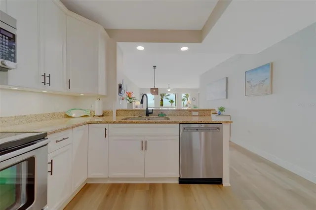 a kitchen with granite countertop white cabinets and white appliances
