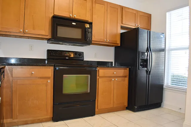 a kitchen with stainless steel appliances granite countertop a refrigerator and a microwave