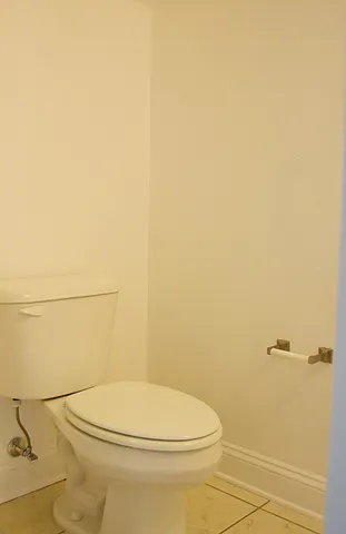 a white toilet sitting next to a white wall